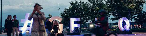 life-size G-F-L-Q letters and people walking 