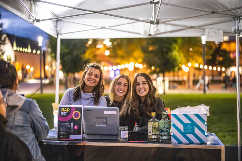 Three young women volunteering and smiling at the camera